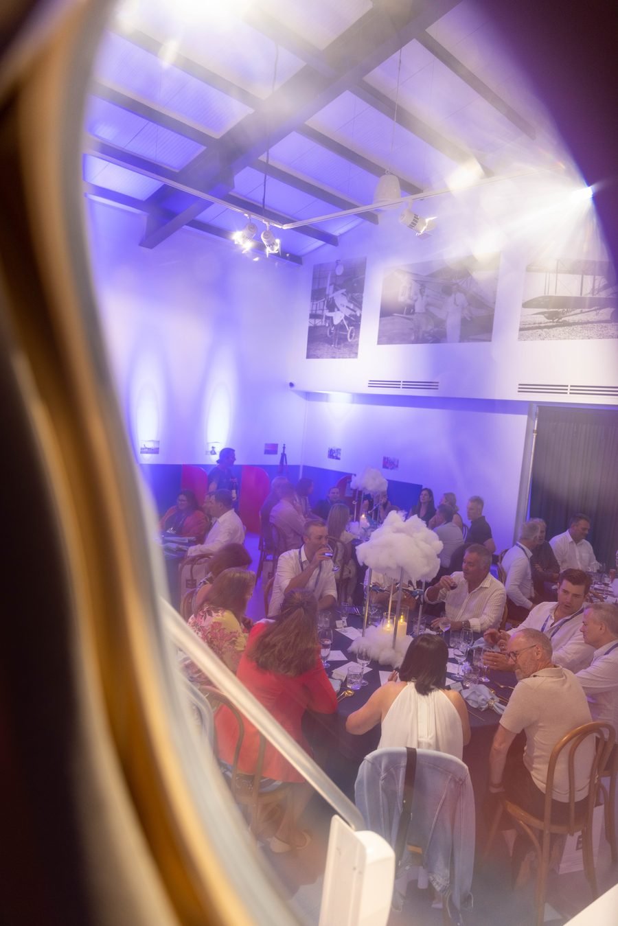 Guests seated for dinner under violet light