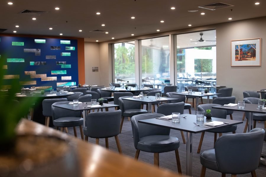 Restaurant dining room with a blue tiled feature wall and set tables