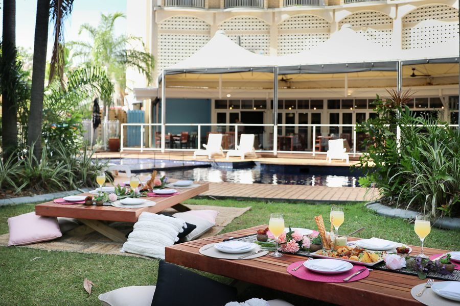 Low picnic tables set on the lawn with the hotel behind