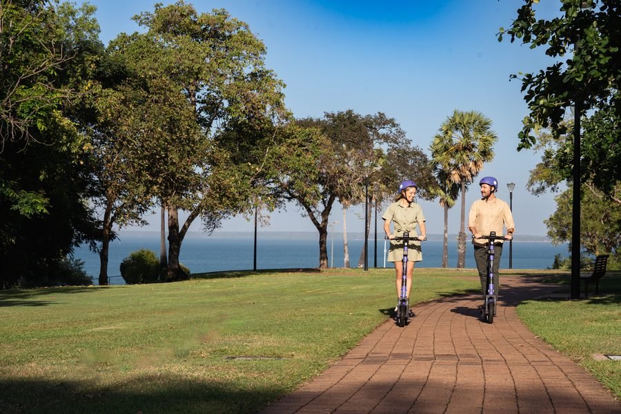 Two riders on the coastal path beneath the trees
