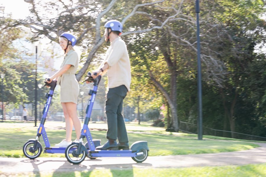 Riders side by side on the path through the park