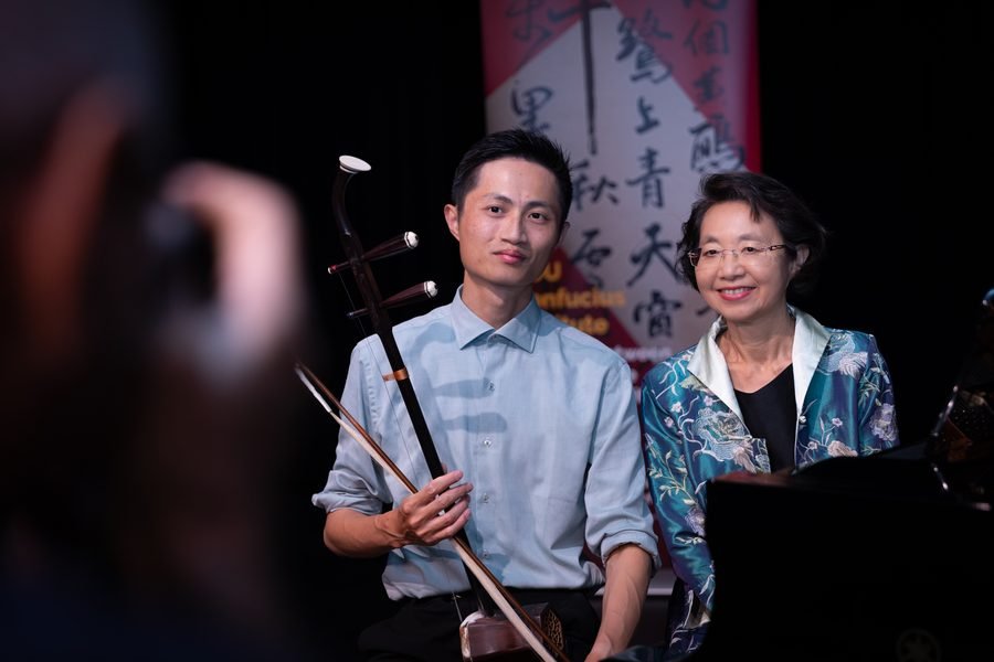 Two performers together backstage with their instrument