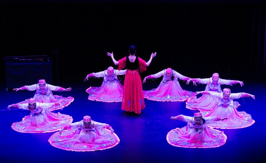 Dancers in blue and violet fanned across the stage