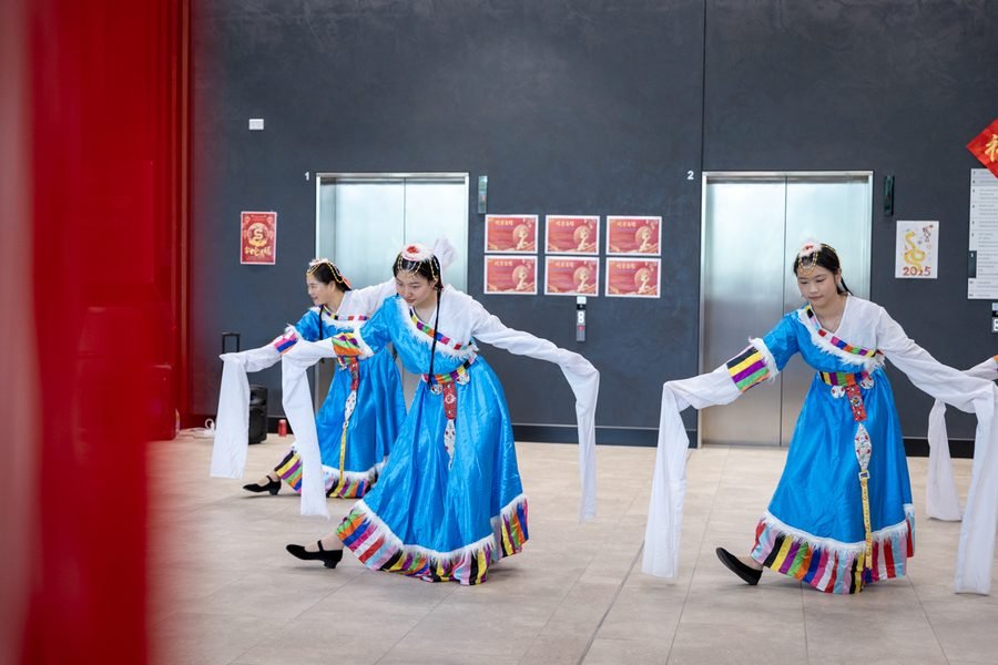 Dancers in blue moving through the gallery space