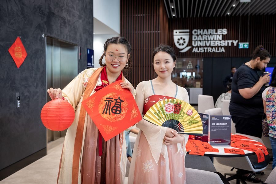 Two guests in traditional dress with painted fans