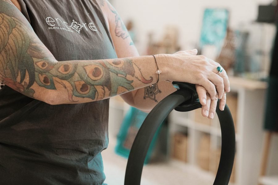 Close detail of hands and forearms braced on a pilates ring
