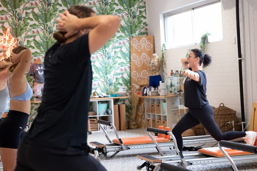 Instructor adjusting a member on the reformer during the open day