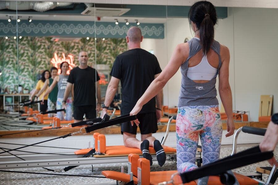 Instructor watching the class from behind, mirrors along the wall