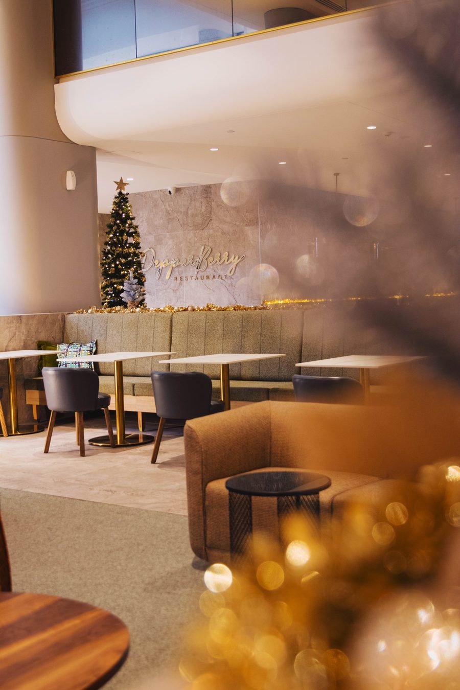 Hotel lounge dressed for Christmas, seating and tree beyond
