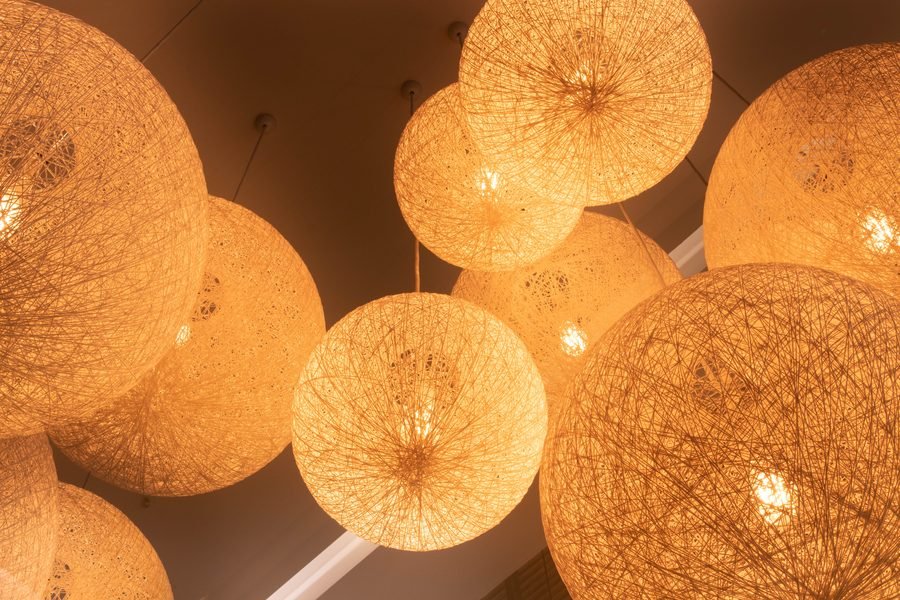 Cluster of woven pendant globes glowing warm against the ceiling