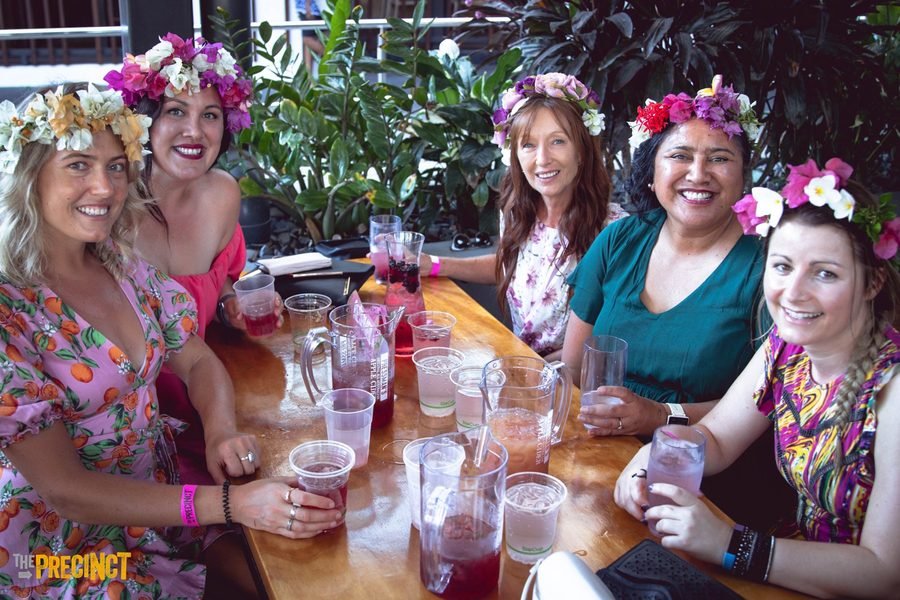 Guests laughing together along a long table with drinks