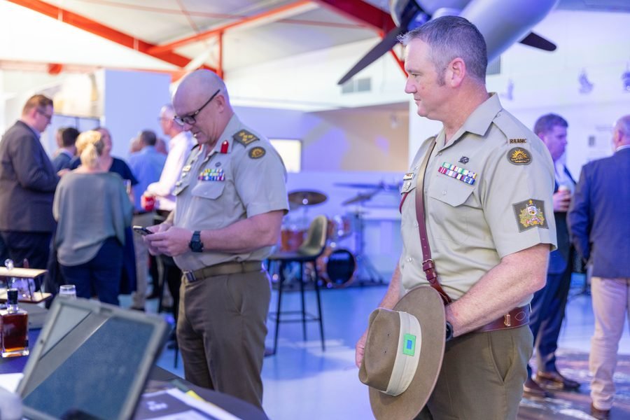 Defence personnel in uniform reading the exhibit panels