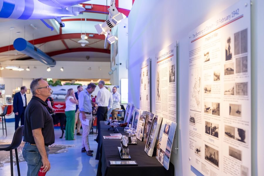 Two guests in conversation in front of the history panels