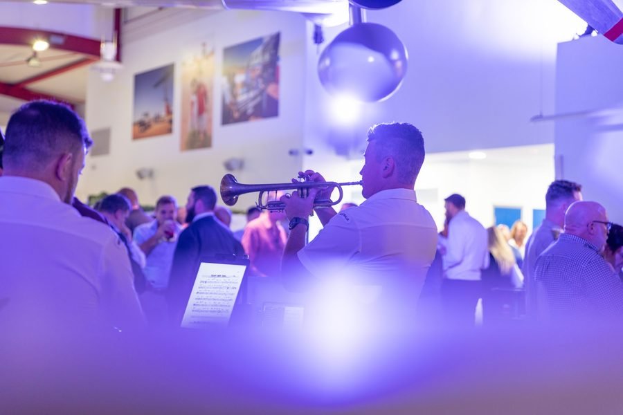 Evening crowd under violet light as the program runs