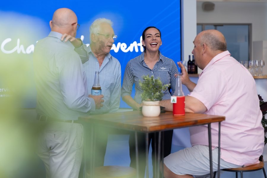 Two guests talking at a table in front of the event screen