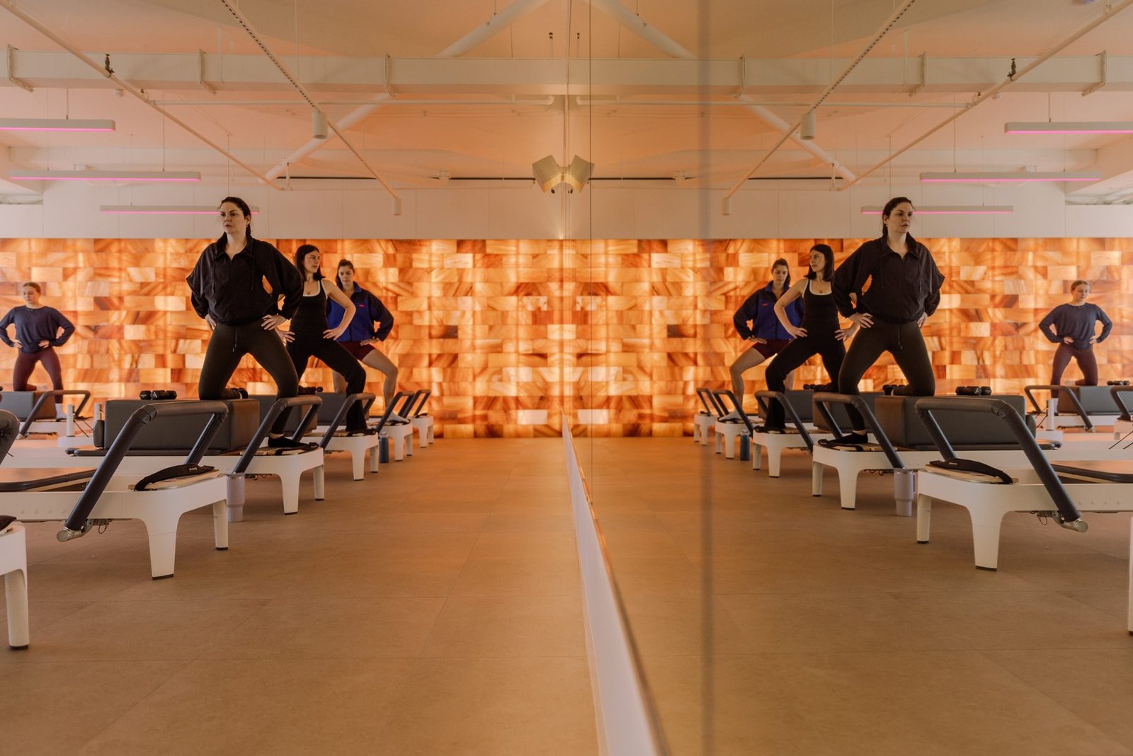 Reformer class standing wide against the backlit salt wall