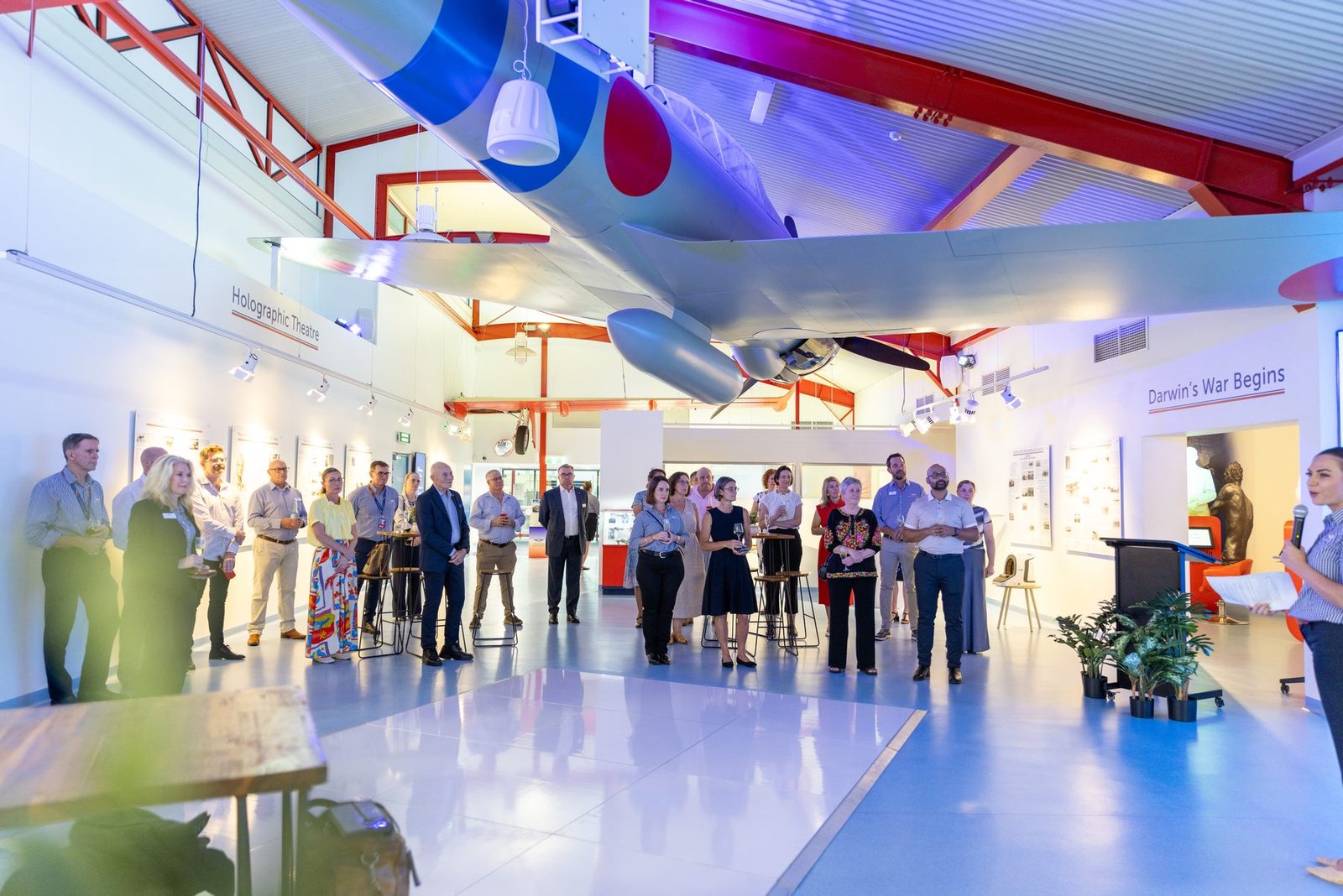 Guests filling the hangar floor beneath a suspended aircraft